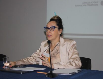 Imagem mostra retrato de Patricia Gainza em uma mesa, durante apresentação