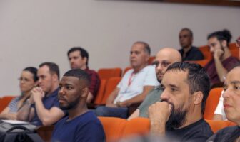 Imagem mostra diversas pessoas em auditório