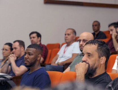 Imagem mostra diversas pessoas em auditório