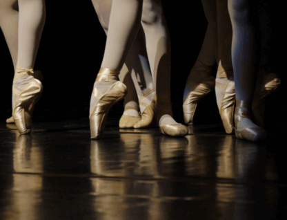 Imagem mostra pés de diversas bailarinas, em palco, dançando