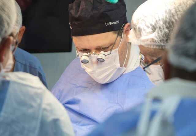 Imagem mostra rosto professor Daniel Bonomi em evidência, com outros participantes do treinamento em volta, com atenção voltada à atividade