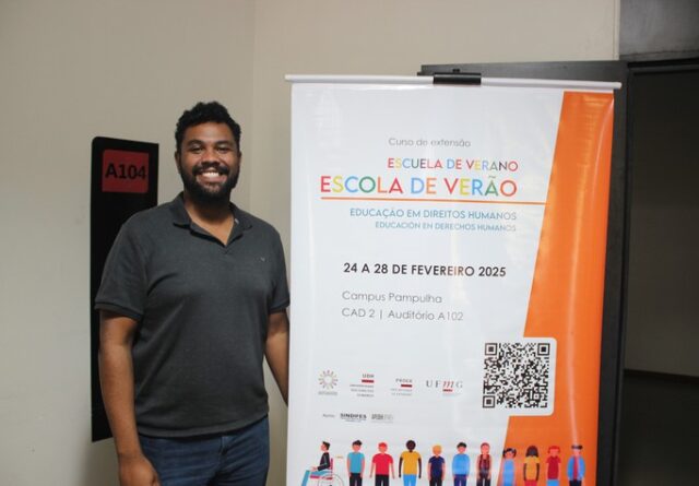 Imagem mostra Maurício Oliveira ao lado de banner sobre a 'Escola de Verão'