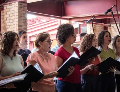 Imagem mostra coristas em apresentação na praça de serviços do campus Pampulha da UFMG