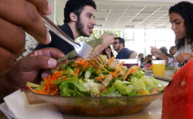 Prato de comida cheio de saladas no Restaurante Universitário da UFMG