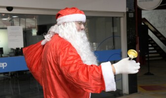 Homem vestido de roupa vermelha caracterizado como Papai Noel circula na Praça de Serviços