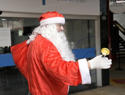 Homem vestido de roupa vermelha caracterizado como Papai Noel circula na Praça de Serviços