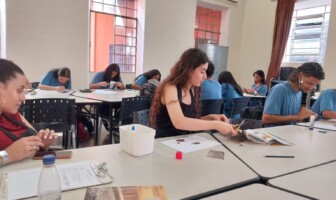 Grupo de estudantes desenvolve atividades em bancadas instaladas em sala do Centro Cultural