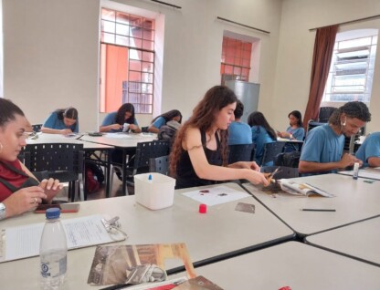 Grupo de estudantes desenvolve atividades em bancadas instaladas em sala do Centro Cultural