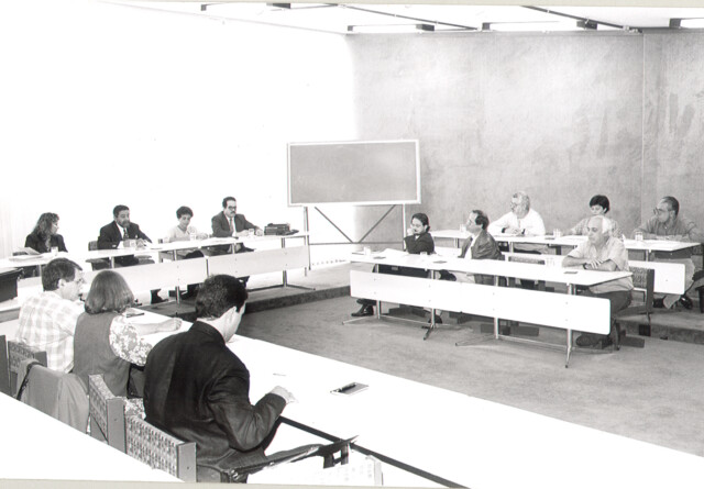 Foto em preto e branco de 1996 de reunião de dirigentes da Universidade, reunidos em torno de mesas, sob a direção do reitor (1994-1998) Tomaz Aroldo da Mota Santos