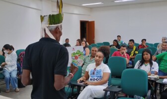 Líder indígena conversa com jovens estudantes.