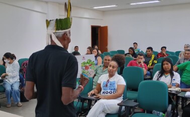 Líder indígena conversa com jovens estudantes.