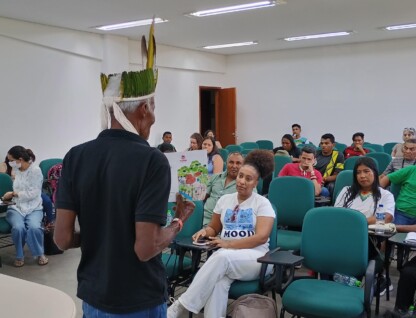 Líder indígena conversa com jovens estudantes.