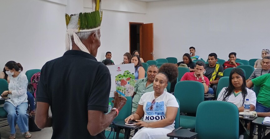 Líder indígena conversa com jovens estudantes.