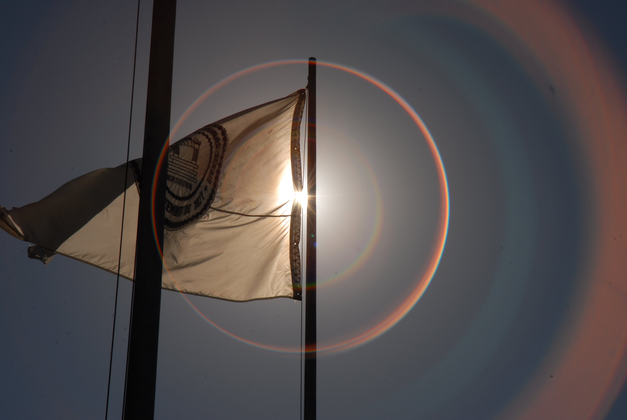 Bandeira UFMG asteada contra a luz do sol