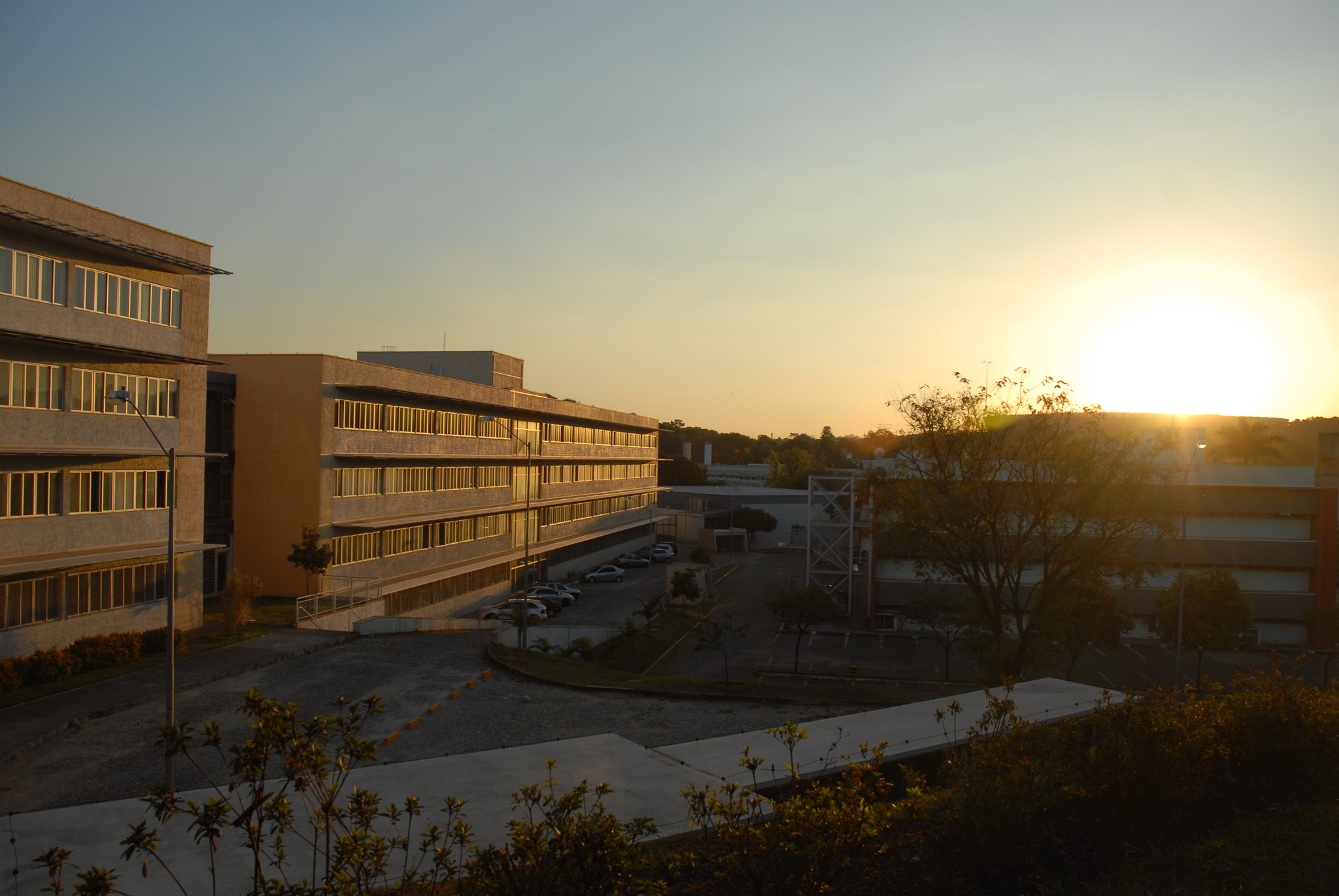 Céu sem nuvens, luz do pôr do sol refletindo nos prédios da escola de enegenharia.