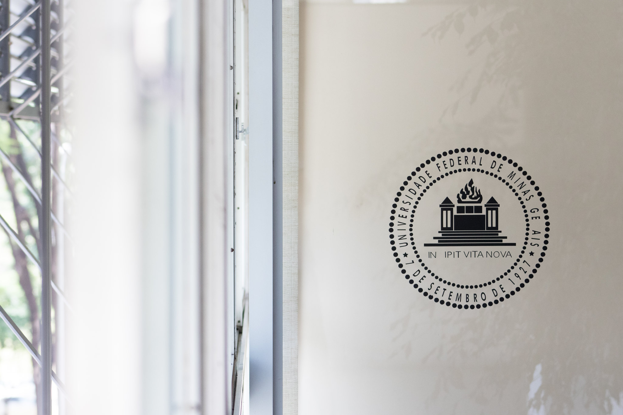 Porta de vidro da Reitoria com brasão da Universidade