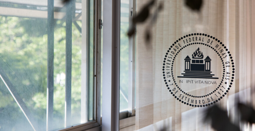 Porta de vidro da Reitoria com brasão da Universidade