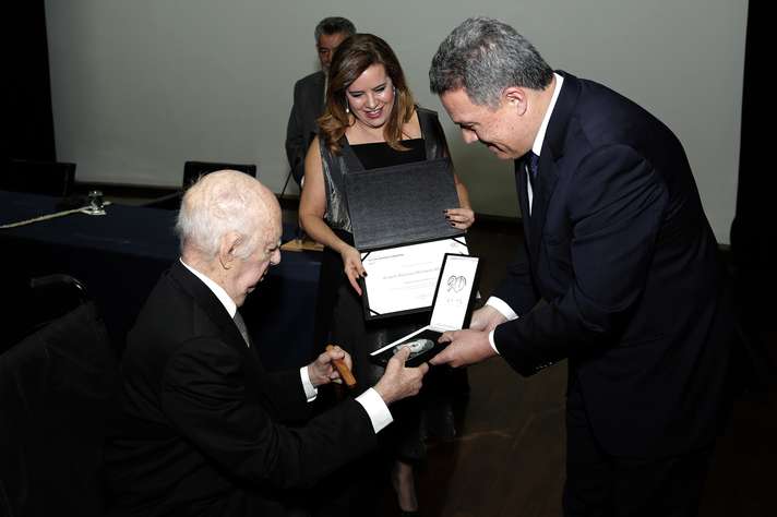 Angelo Machado recebeu a medalha do reitor Jaime Ramírez e da vice-reitora Sandra Goulart Almeida. Foto: Foca Lisboa / UFMG