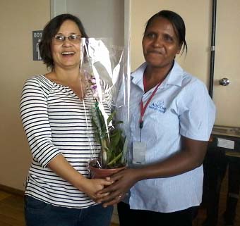 Lucimara recebendo a orquídea das mãos de Maria Helena