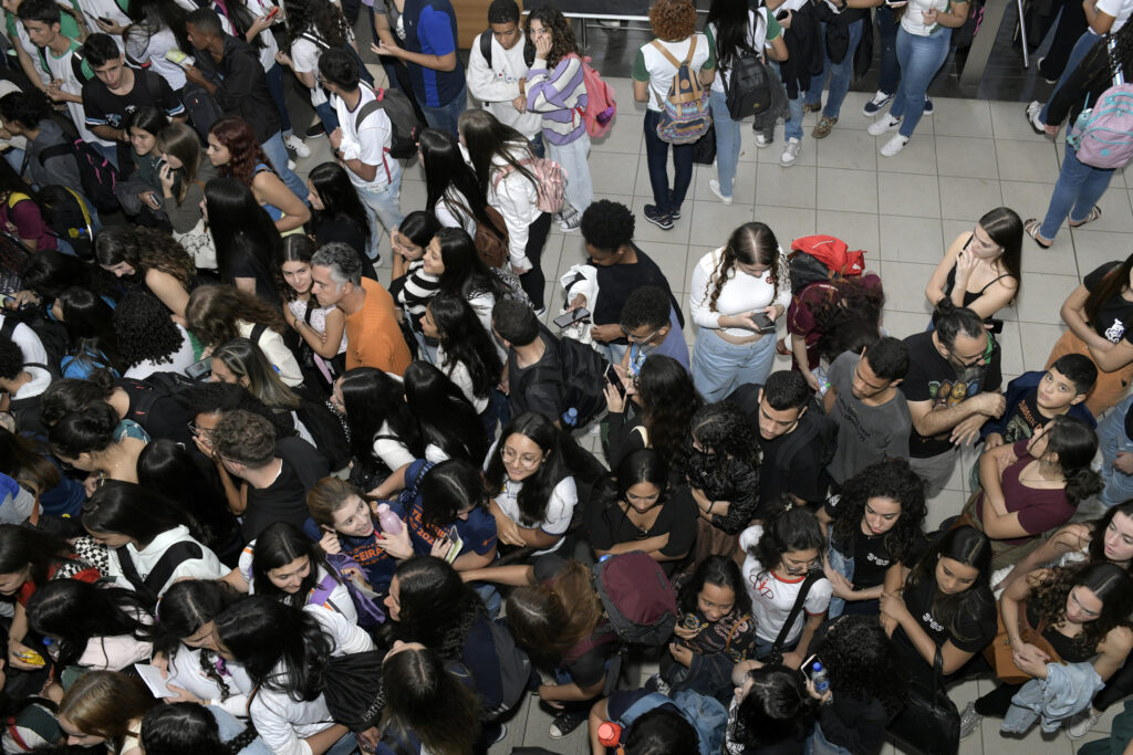 Estudantes do ensino médio se acumulam em fila na porta de auditório